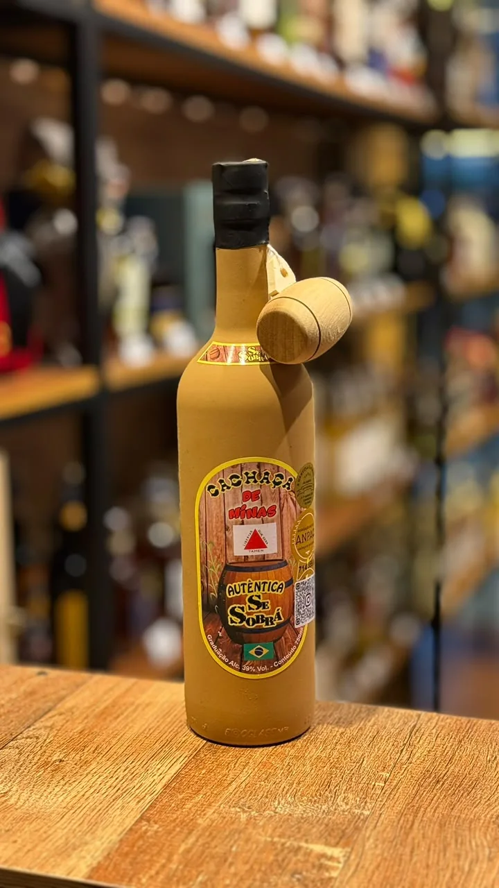 Garrafa âmbar de cachaça fotografada no balcão do Empório
